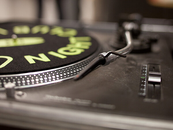 Schallplattenspieler mit neongürner Aufschrift.