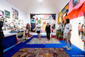 Ein Raum, der dem Wohnraum der Künstlerin in ihrem Atelier nachempfunden ist. Mit Mobilar, Fotos und Reiseerinnerungen, Büchern, Kinderzeichnungen ihres Sohnes etc. ausgestatten