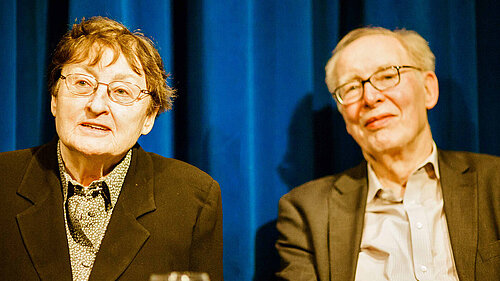 Portraitfoto von Erika und Ulrich Gregor vor einem blauen Vorhang